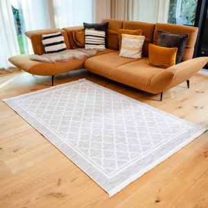 Teppich Oslo ausgelegt im Wohnzimmer mit moderner Couch und Holzboden