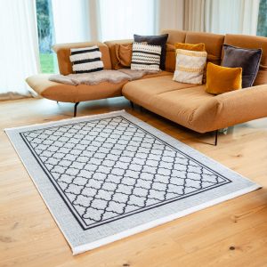 Teppich Bern ausgelegt im Wohnzimmer mit moderner Couch und Holzboden