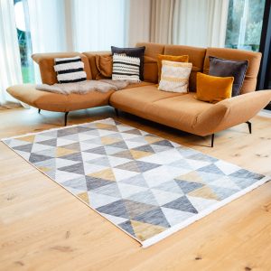 Teppich Kobe im Wohnzimmer mit moderner Couch und hellem Parkett