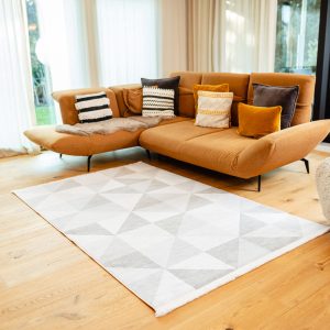 Teppich Osaka im Wohnzimmer mit cognacfarbener Couch und hellem Boden